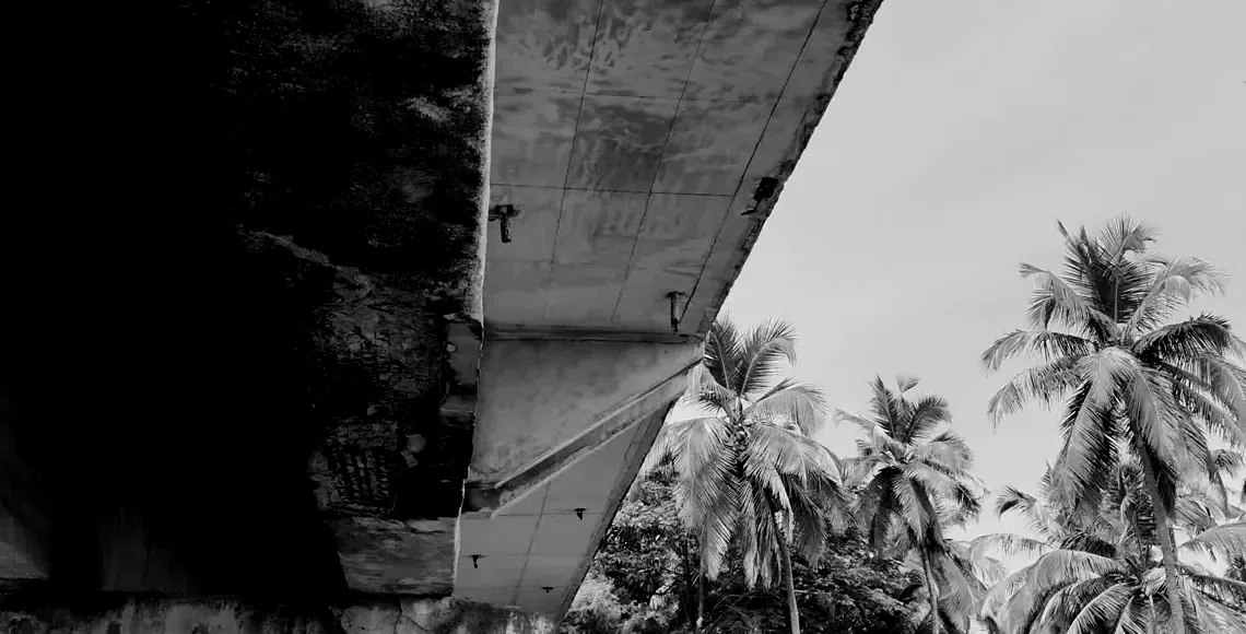 A drone photo looking up at weathered concrete girders.