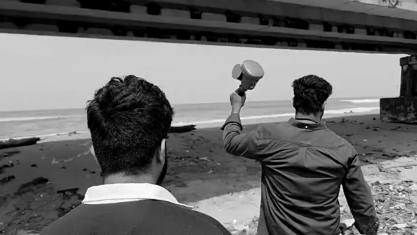Two CORRSENS engineers under a bridge, one holding a LiDAR scanner up to the girders.
